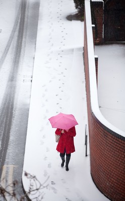 180113 - Snow hits south Wales -A worker makes her way through the snow in Cardiff