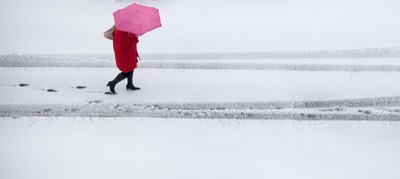 180113 - Snow hits south Wales -A worker makes her way through the snow in Cardiff