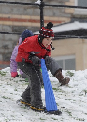 180113 - Heavy Snowfall in South Wales -Children and adults enjoy sledging in the snow in Penarth near Cardiff following heavy snowfall in South Wales