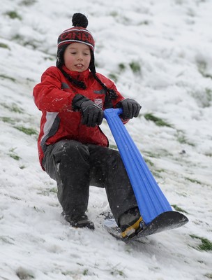 180113 - Heavy Snowfall in South Wales -Children and adults enjoy sledging in the snow in Penarth near Cardiff following heavy snowfall in South Wales