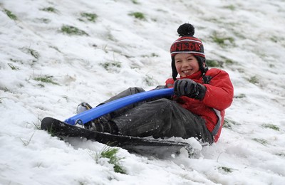 180113 - Heavy Snowfall in South Wales -Children and adults enjoy sledging in the snow in Penarth near Cardiff following heavy snowfall in South Wales