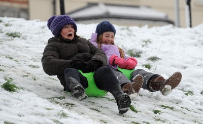 180113 - Heavy Snowfall in South Wales -Children and adults enjoy sledging in the snow in Penarth near Cardiff following heavy snowfall in South Wales