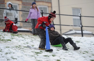 180113 - Heavy Snowfall in South Wales -Children and adults enjoy sledging in the snow in Penarth near Cardiff following heavy snowfall in South Wales