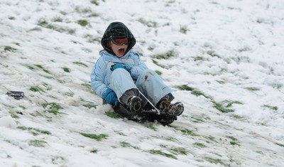 180113 - Heavy Snowfall in South Wales -Children and adults enjoy sledging in the snow in Penarth near Cardiff following heavy snowfall in South Wales