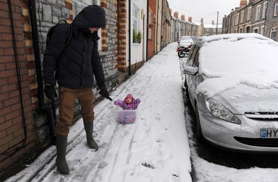 180113 - Heavy Snowfall in South Wales -A man finds an alternative way to tow his baby in the snow in Penarth near Cardiff following heavy snowfall in South Wales