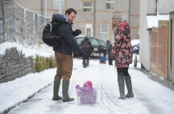 180113 - Heavy Snowfall in South Wales -A couple find an alternative way to tow their baby in the snow in Penarth near Cardiff following heavy snowfall in South Wales