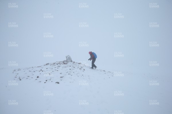 101297 - Snow in South Wales -  A walker approaches the highest point in southern Britain as she reaches the top of Pen y Fan, the highest peak in South Wales