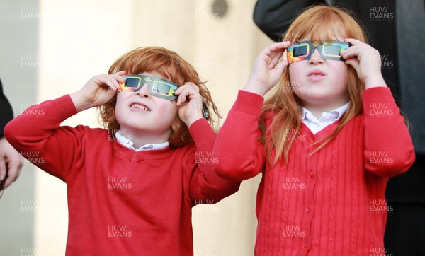 200315 - Picture shows Jojo and Ellie Roach watching the solar eclipse on the steps of the National Museum, Cardiff