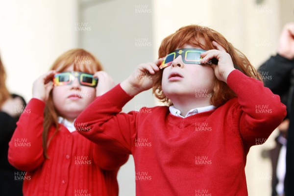 200315 - Picture shows Ellie and Jojo Roach watching the solar eclipse on the steps of the National Museum, Cardiff