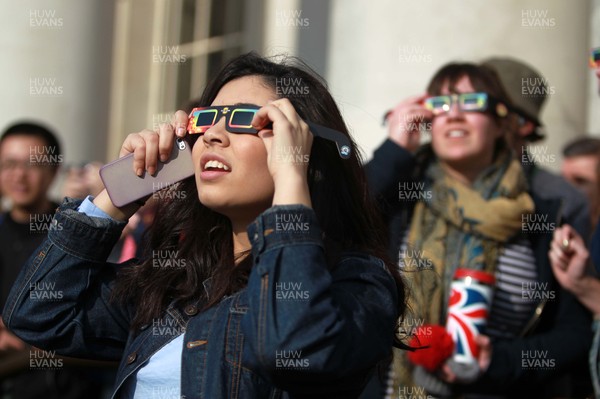 200315 - Picture shows people watching the solar eclipse on the steps of the National Museum, Cardiff