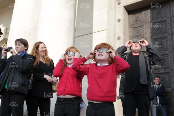 200315 - Picture shows Jojo and Ellie Roach watching the solar eclipse on the steps of the National Museum, Cardiff