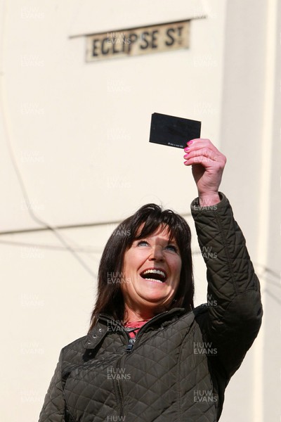 200315 - Picture shows Shirley Debono, a resident of Eclipse Street, Adamstown, Cardiff watching the solar eclipse