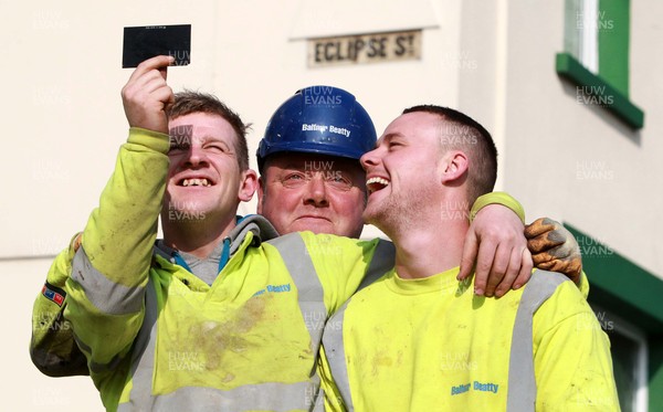 200315 - Picture shows workmen on Eclipse Street, Adamstown, Cardiff watching the solar eclipse