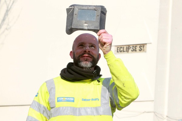 200315 - Picture shows a workmen using a welding mask on Eclipse Street, Adamstown, Cardiff to watch the solar eclipse