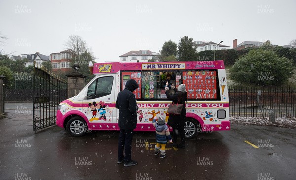 310121 - Snow, South Wales - An ice cream van serves customers in Roath Park, Cardiff as snow falls across Wales on Sunday
