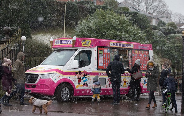 310121 - Snow, South Wales - An ice cream van serves customers in Roath Park, Cardiff as snow falls across Wales on Sunday