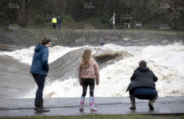 200221 - Picture shows members of the public looking on at the high river level of the River Taff in Cardiff, the area has been put under an amber weather warning for Saturday