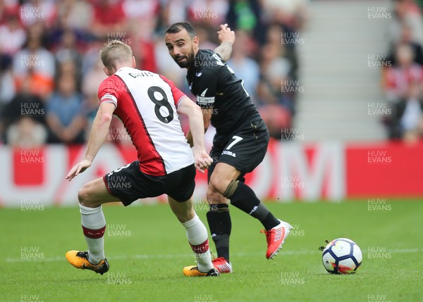 120817 - Southampton v Swansea City, Premier League - Leon Britton of Swansea City plays the ball past Steven Davis of Southampton