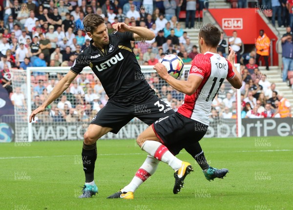 120817 - Southampton v Swansea City, Premier League - Federico Fernandez of Swansea City and Dusan Tadic of Southampton compete for the ball