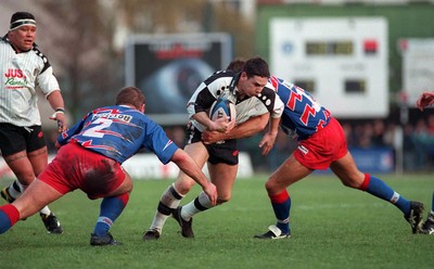 121298 - Stade Francais v Pontypridd - Heineken Cup Quarter Final - Jason Lewis of Pontypridd is tackled by Cliff Mytton and Laurent Pedrosa (2) 