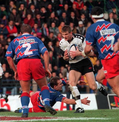 121298 - Stade Francais v Pontypridd - Heineken Cup Quarter Final - Dafydd James of Pontypridd is tackled by Richard Dourthe 