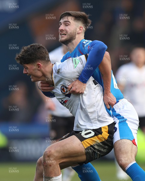 090324 - Stockport County v Newport County - Sky Bet League 2 - Offrande Zanzala of Newport County is held back by Ethan Bye of Stockport County