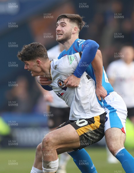 090324 - Stockport County v Newport County - Sky Bet League 2 - Seb Palmer-Houlden of Newport County is held back by Ethan Bye of Stockport County