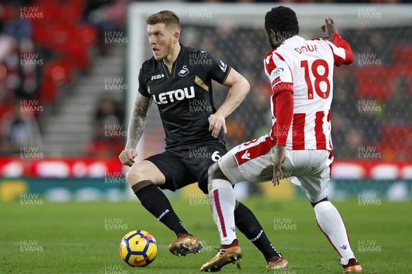 021217 - Stoke City v Swansea City, Premier League - Alfie Mawson of Swansea City (left) in action with Mame Biram Diouf of Stoke City