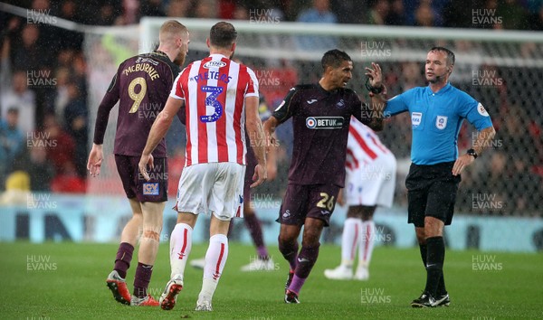 180918 - Stoke City v Swansea City - SkyBet Championship - Oliver McBurnie of Swansea City and Erik Pieters of Stoke City look towards referee Paul Tierney