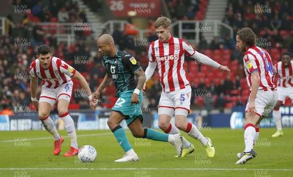 250120 - Stoke City v Swansea City - Sky Bet Championship - Andre Ayew of Swansea is caught by Liam Lindsay of Stoke City and Danny Batth of Stoke City  