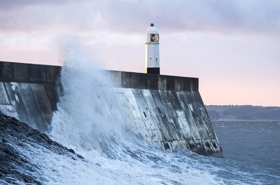 210918 - Picture shows the waves crash on the lighthouse in Porthcawl, South Wales, as Storm Branagh starts to hit the UK