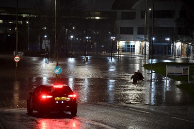 160220 - South Wales Flooding during Storm Dennis - Two men walk through flood water in Nantgarw, South Wales