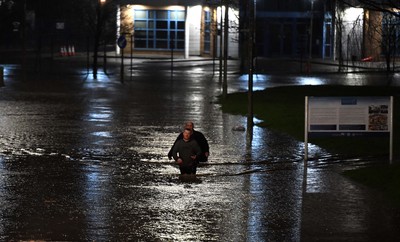 160220 - South Wales Flooding during Storm Dennis - Two men walk through flood water in Nantgarw, South Wales