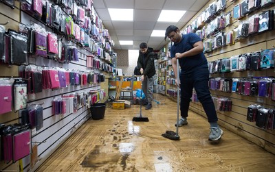 160220 -  Staff at a phone and accessories shop on Taff Street in Pontypridd begin to clear up after their shop was flooded after the River Taff bursts it's banks from the effects of storm Dennis