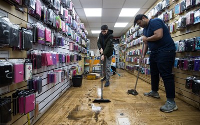 160220 -  Staff at a phone and accessories shop on Taff Street in Pontypridd begin to clear up after their shop was flooded after the River Taff bursts it's banks from the effects of storm Dennis