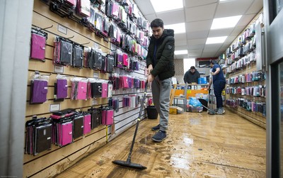 160220 -  Staff at a phone and accessories shop on Taff Street in Pontypridd begin to clear up after their shop was flooded after the River Taff bursts it's banks from the effects of storm Dennis