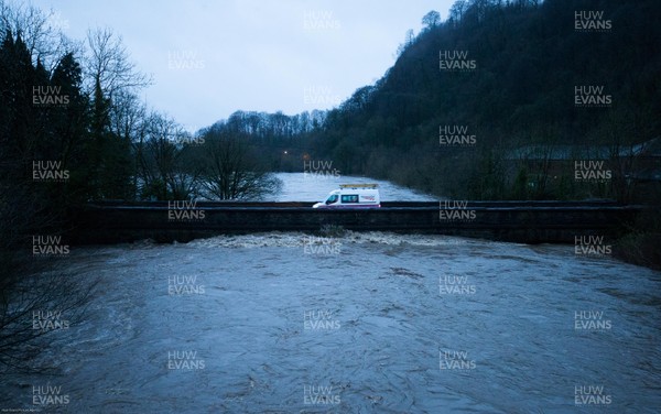 160220 - A van crosses a bridge over the River Taff at Taffs Well north of Cardiff in south Wales as the river bursts it's banks from the effects of storm Dennis