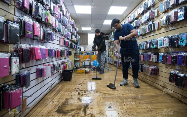 160220 -  Staff at a phone and accessories shop on Taff Street in Pontypridd begin to clear up after their shop was flooded after the River Taff bursts it's banks from the effects of storm Dennis