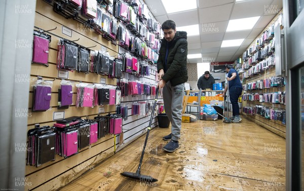 160220 -  Staff at a phone and accessories shop on Taff Street in Pontypridd begin to clear up after their shop was flooded after the River Taff bursts it's banks from the effects of storm Dennis