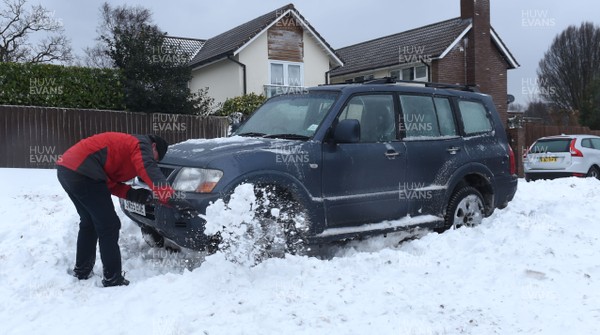 020318 - Weather - A man tries to free his car in Penarth near Cardiff, South Wales after being hit by Storm Emma