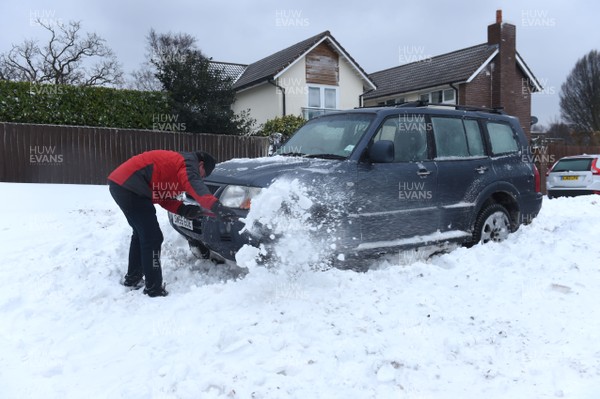 020318 - Weather - A man tries to free his car in Penarth near Cardiff, South Wales after being hit by Storm Emma