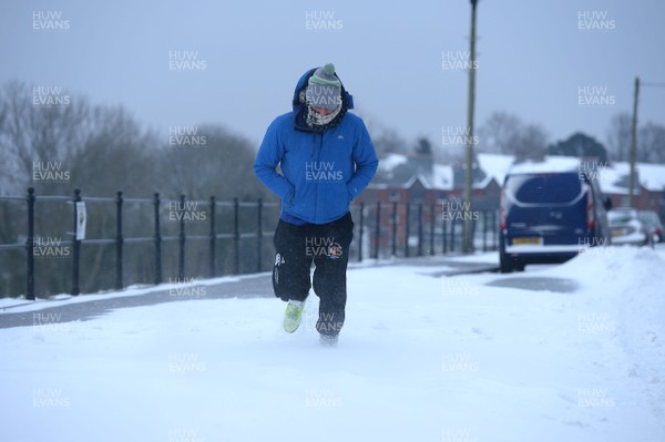 020318 - Weather - Alex Bywater walks through deep snow in Penarth near Cardiff, South Wales after being hit by Storm Emma