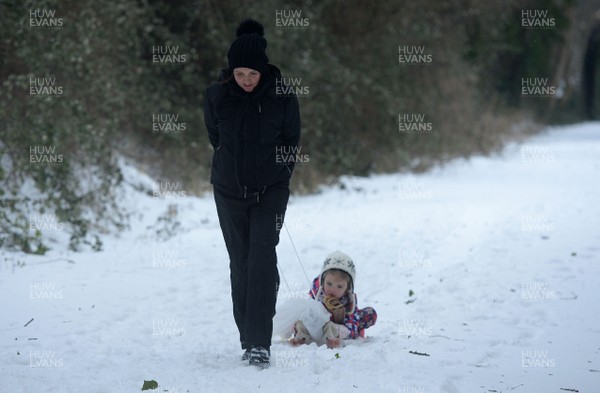 020318 - Weather - A woman tries to drag he child's sledge in Penarth near Cardiff, South Wales after being hit by Storm Emma