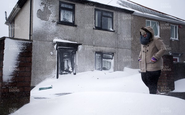 020318 - Picture shows a women struggling through the heavy snowfall in Pontypridd, South Wales after Storm Emma hit the area overnight