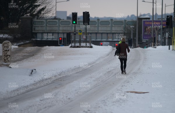 020318 - Storm Emma, Cardiff - A pedestrian makes her way down one of the usually busy rush hour main roads in Cardiff city centre this morning after storm Emma hits south Wales and the South West, forcing many to stay at home