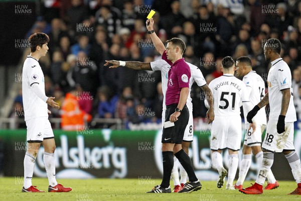251117 - Swansea City v AFC Bournemouth, Premier League - Referee Stuart Attwell shows the yellow card to Ki Sung-Yueng of Swansea City