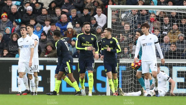 140117 - Swansea City v Arsenal - Premier League - Olivier Giroud of Arsenal celebrates scoring a goal as Swansea look on dejected by Chris Fairweather/Huw Evans Agency