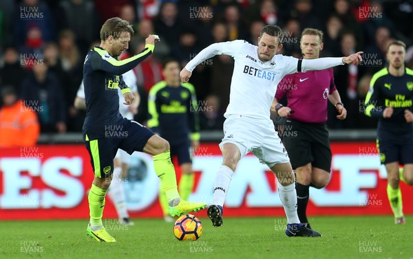 140117 - Swansea City v Arsenal - Premier League - Gylfi Sigurdsson of Swansea City is tackled by Shkodran Mustafi of Arsenal