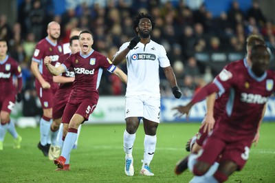 261218 - Swansea City v Aston Villa - SkyBet Championship - Wilfried Bony of Swansea City looks dejected as he misses a shot from the penalty spot as James Chester of Aston Villa celebrates in the background