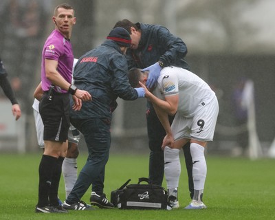 210226 - Swansea City v Bristol City - Sky Bet Championship - Zan Vipotnik of Swansea City holds his head as he is treated for an injury